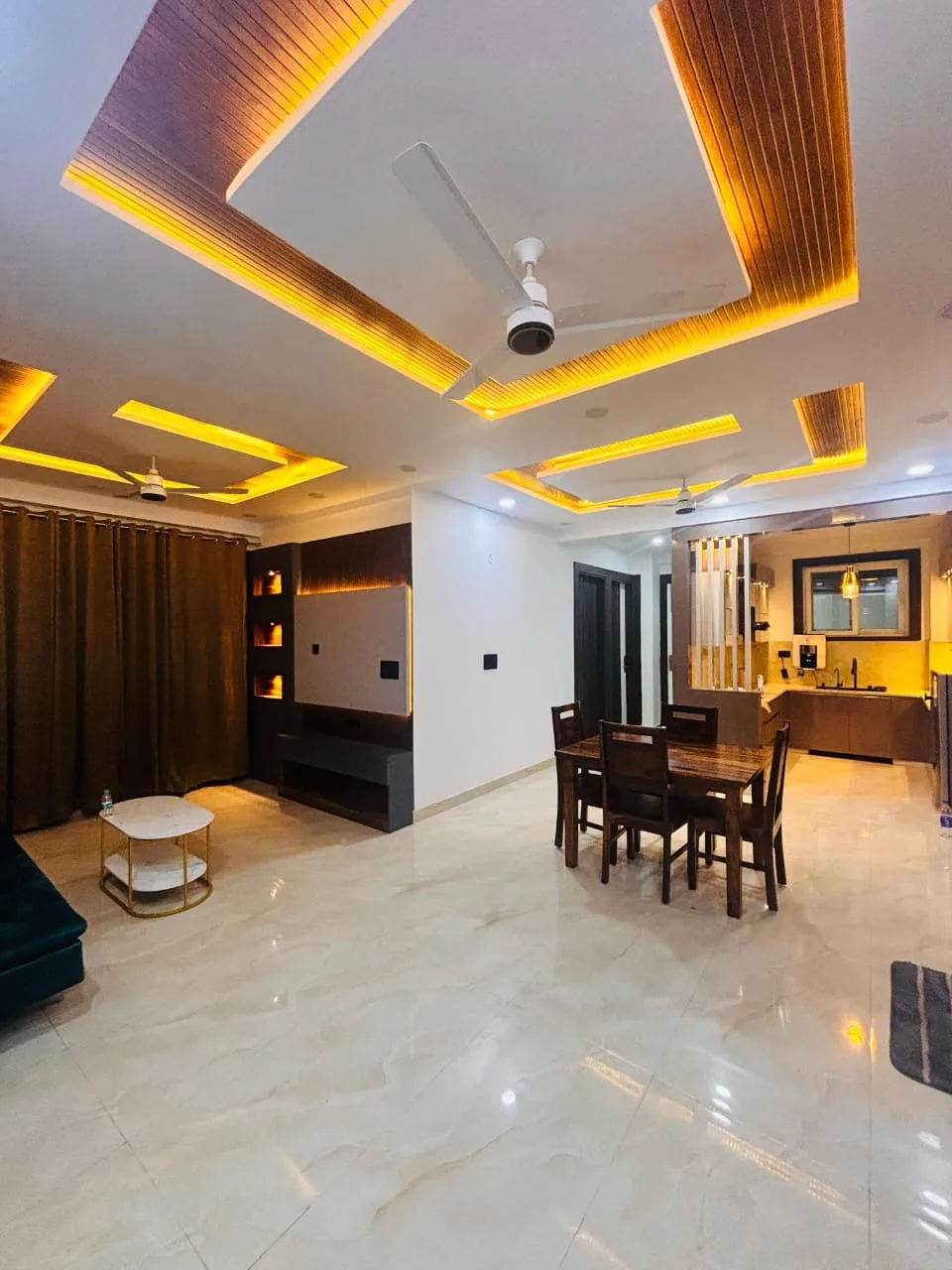 StayHolic living and dining interior with warm ceiling lighting.