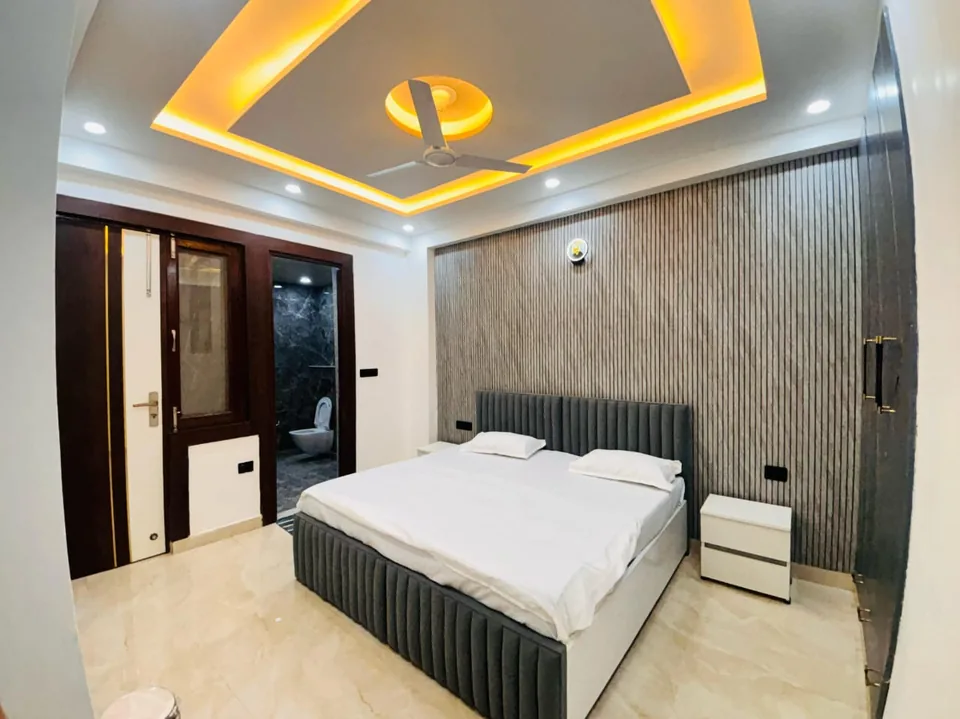 StayHolic private bedroom interior with an upholstered bed and feature wall.