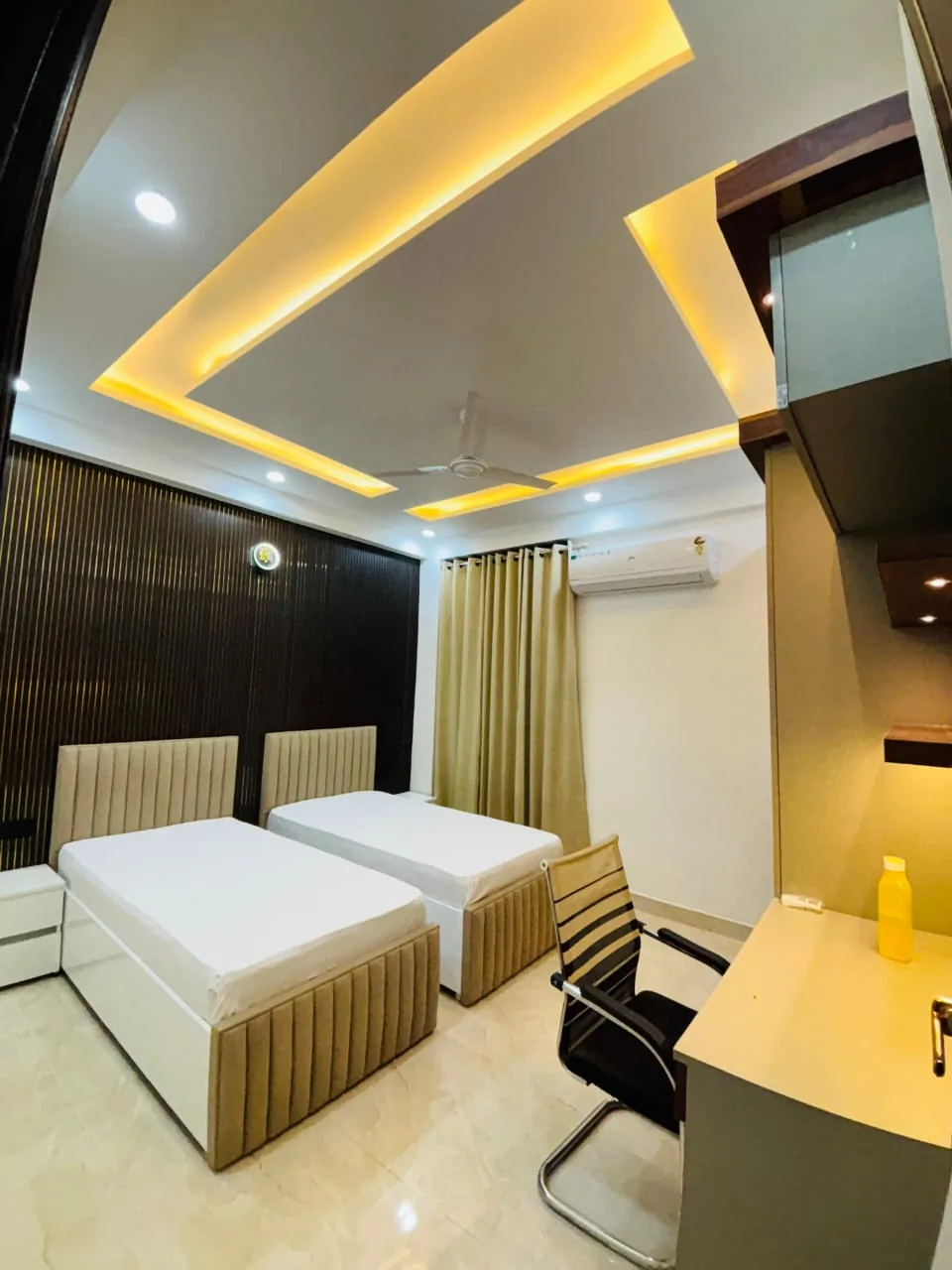 StayHolic shared bedroom interior with two beds and a desk.